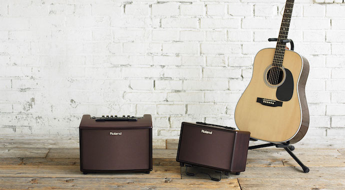 Acoustic Guitar on Stand Next to Amps
