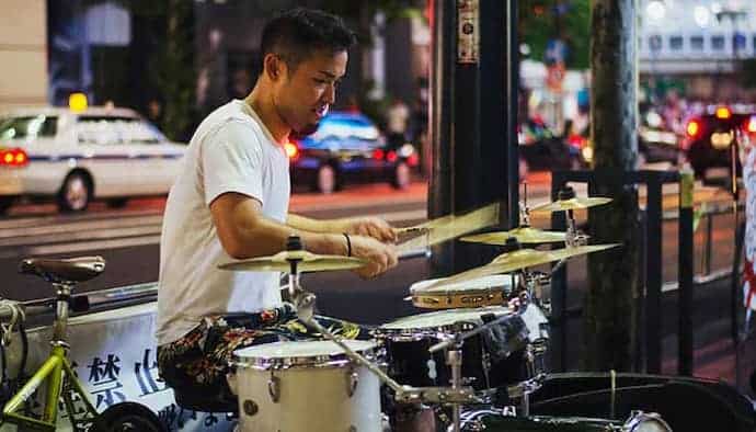 Drummer Sitting on a Throne Playing Drums Outdoors