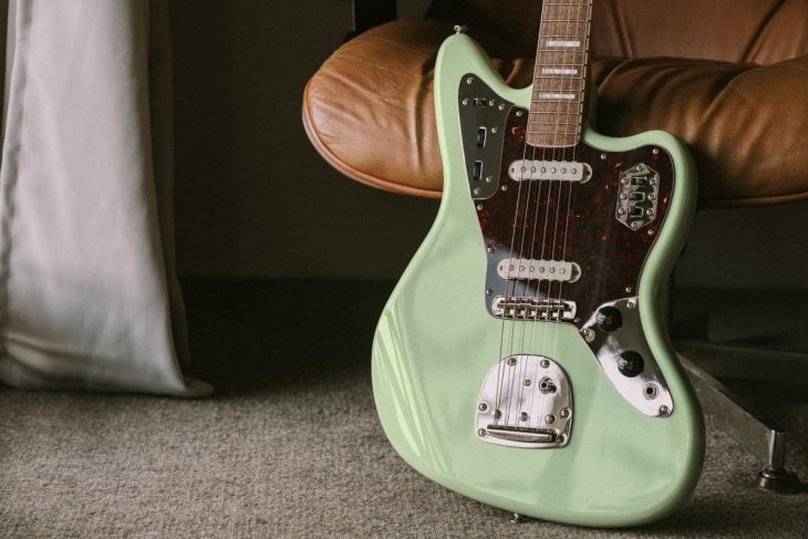 Squier Classic Vibe ‘70s Jaguar Placed against a Leather Couch